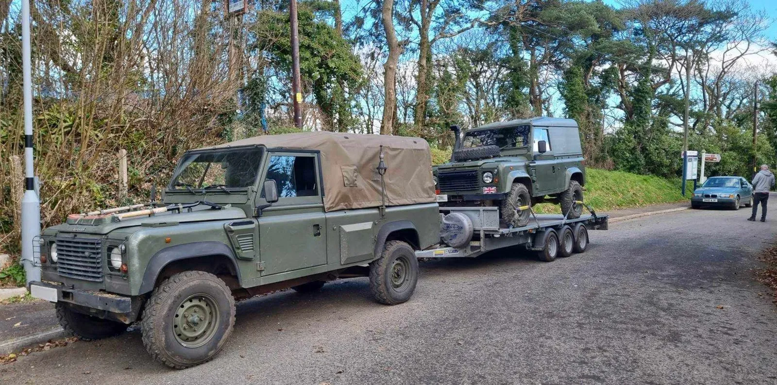 Land Rover towing a trailer carrying another Land Rover